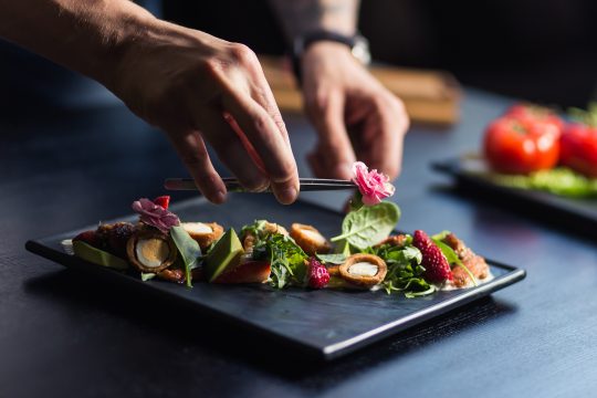 Derniers préparatifs d'un plat de cuisine avant d'être servi.